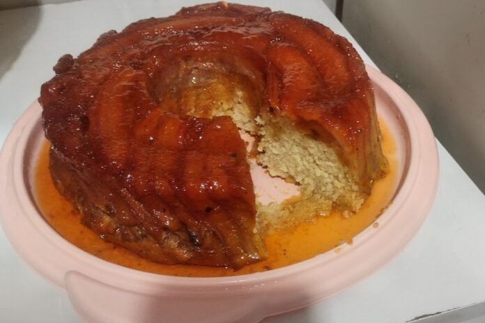 Bolo de banana fofinho com calda caramelizada desenformado inteiro no prato, feito pela leitora Nicolly